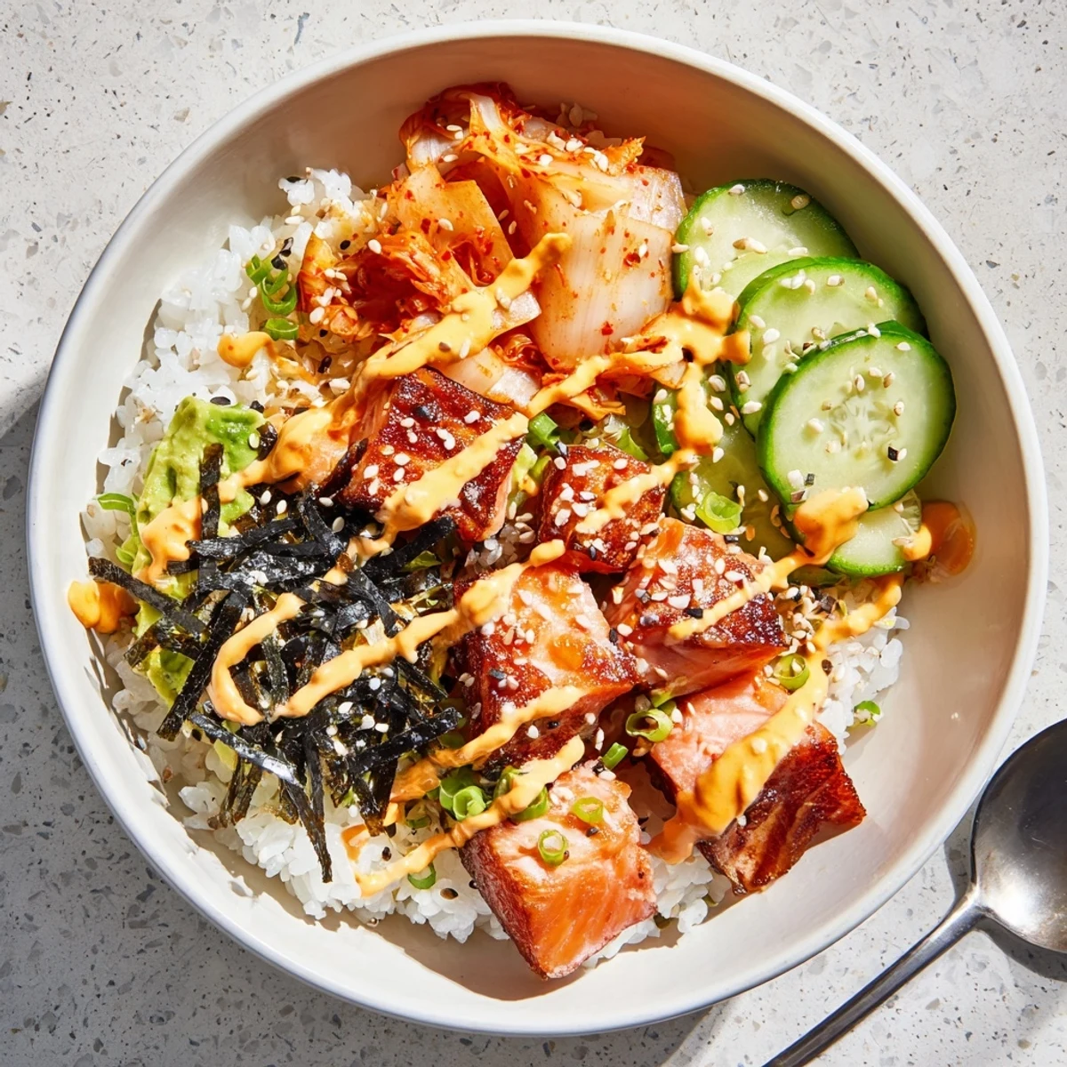 Crispy Salmon Rice Bowl topped with spicy mayo, fresh avocado, and tangy kimchi.  