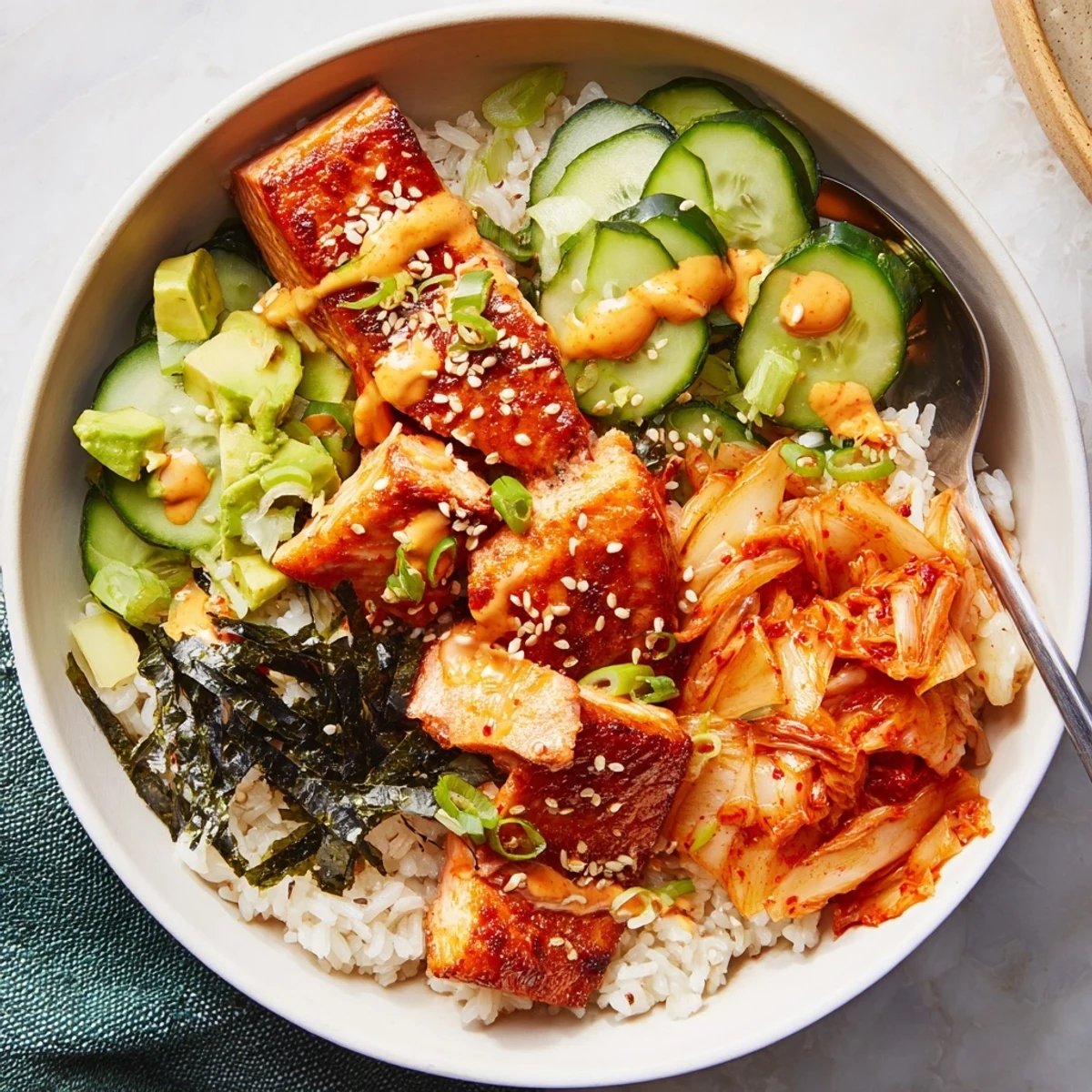 Flavorful Crispy Salmon Rice Bowl with garlic, kimchi, and zesty toppings delight.