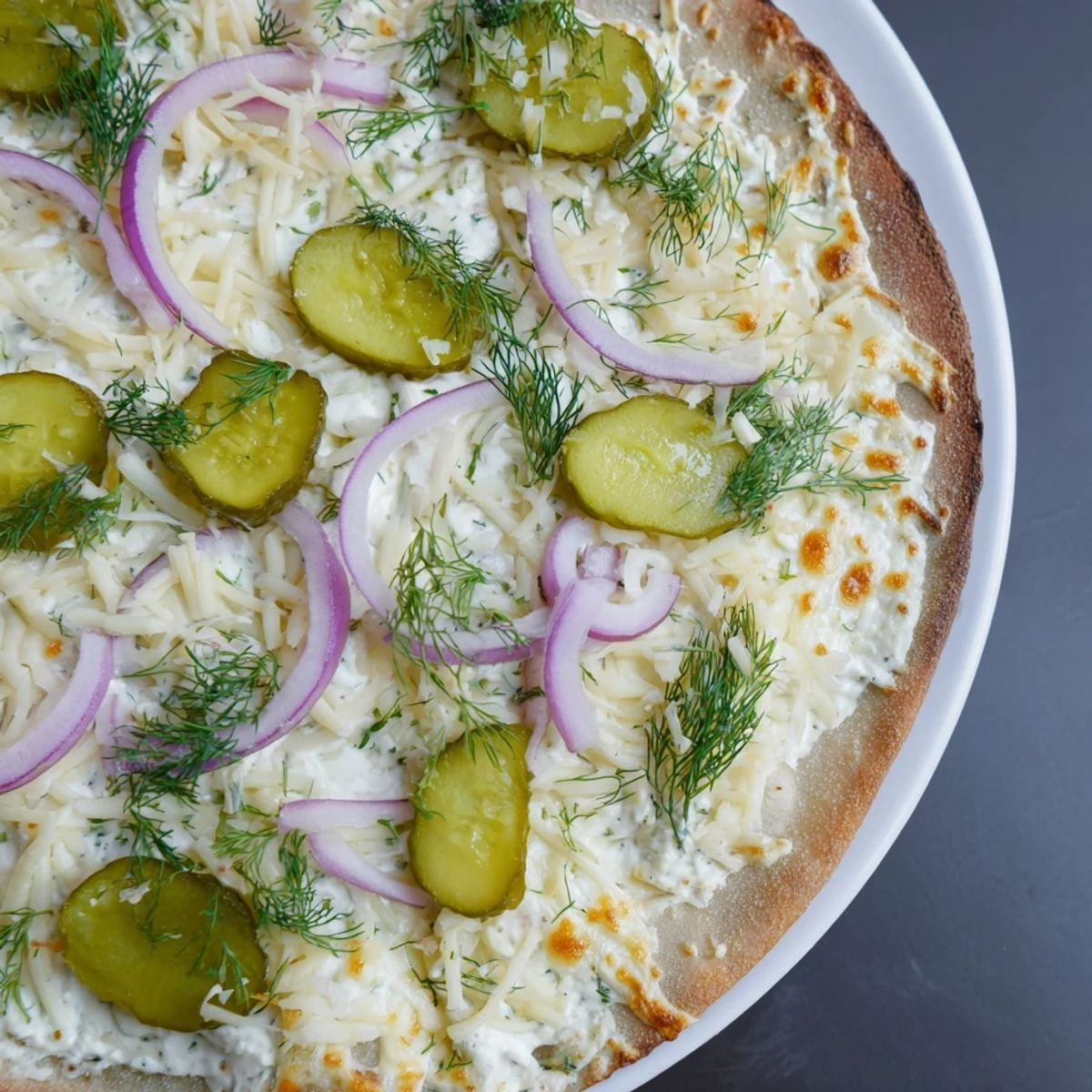 Deliciously unique pickle pizza, featuring melted mozzarella and zesty crème fraîche sauce.