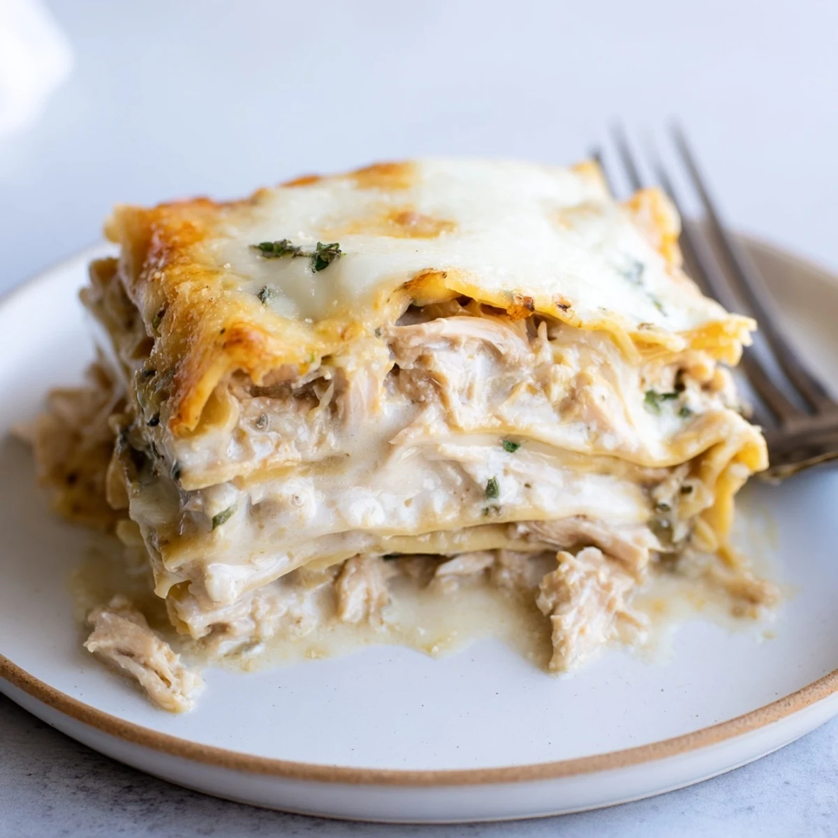 Savory rosemary chicken lasagna baked to perfection, topped with bubbling cheese and herbs.