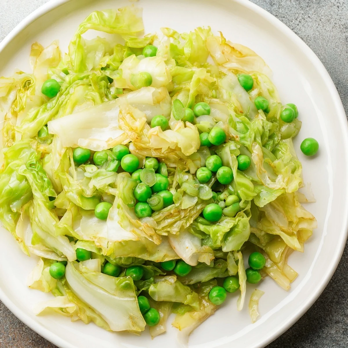 Steaming bowl of flavorful Cabbage Stir-Fry, with vibrant green peas and savory garlic soy.