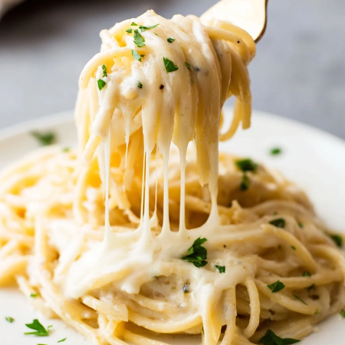 Tender spaghetti entwined in a glossy, cheese sauce, ready for enjoying the Three-Cheese Spaghetti.