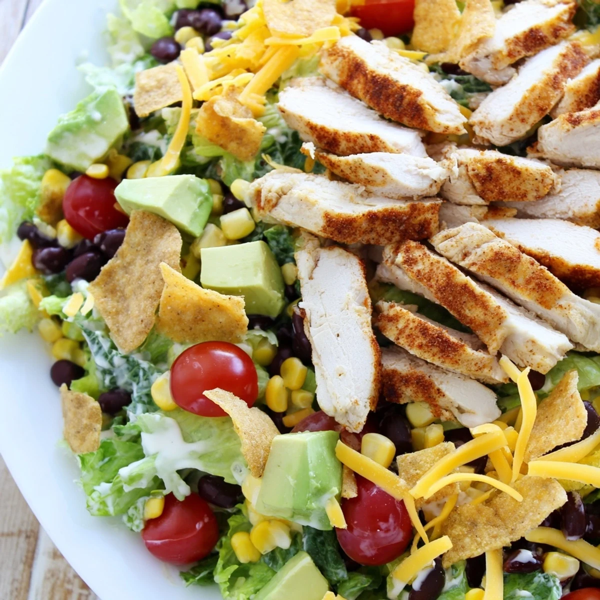 A vibrant bowl of Crunchy Taco Chicken Salad, packed with seasoned chicken, black beans, corn, and fresh avocado.
