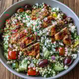 Tossing the Mediterranean Pearl Couscous Chicken Bowls with a zesty red wine vinaigrette highlights olives and fresh parsley.