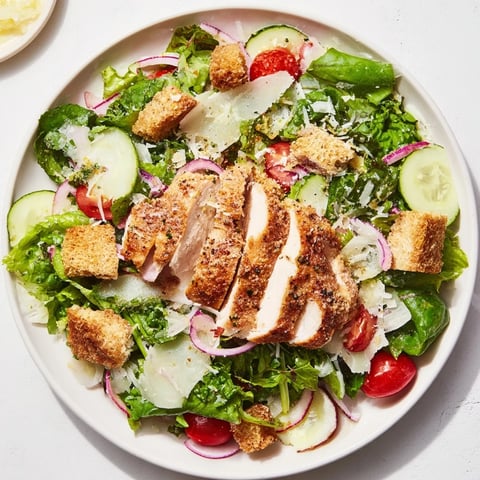 Crisp, sliced Lemon Parmesan Chicken Salad showcases juicy chicken atop vibrant greens, ready to enjoy.