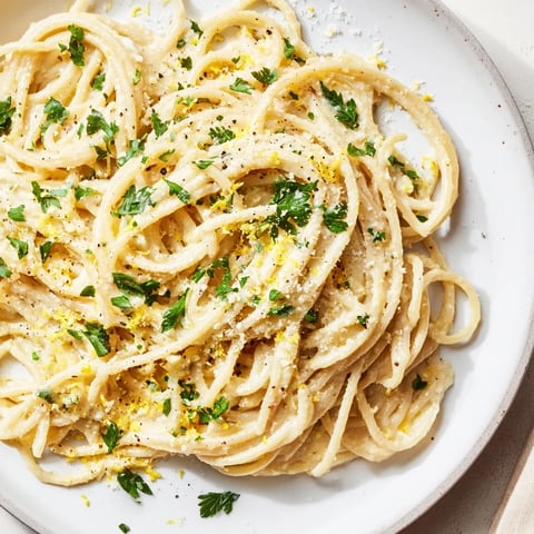 Vibrant photo of Creamy Roasted Cauliflower Garlic Pasta, garnished with fresh herbs and parmesan cheese.