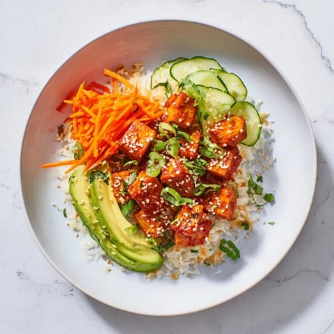 Spicy chili-mayo sauce coats the baked tofu in these flavorful vegetarian bowls.