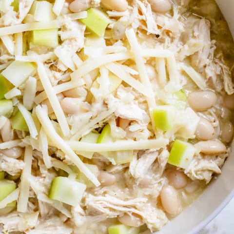 Close-up of a flavorful 35-Minute White Cheddar Apple Chicken Chili with visible chicken and beans.