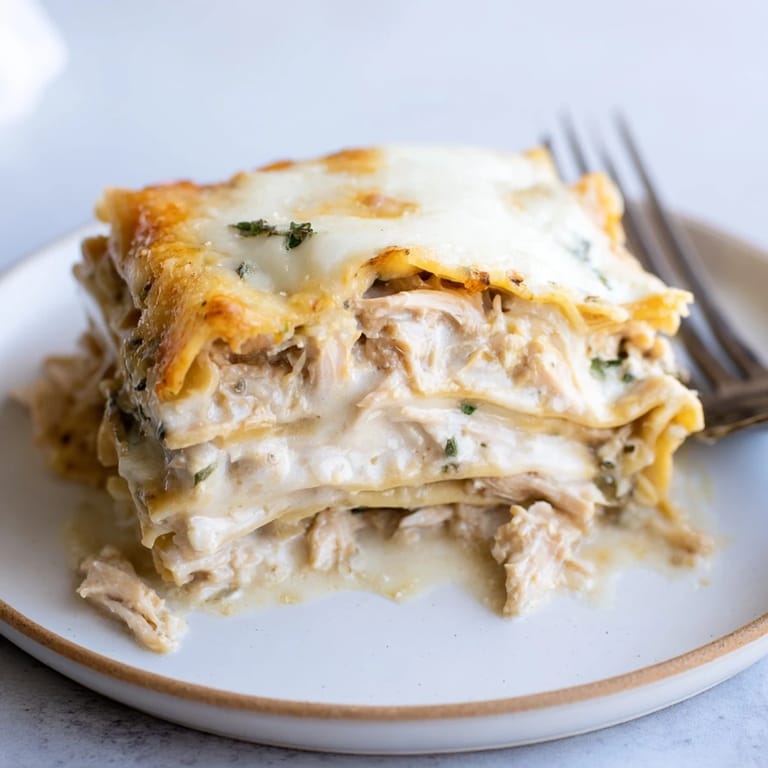 Savory rosemary chicken lasagna baked to perfection, topped with bubbling cheese and herbs.