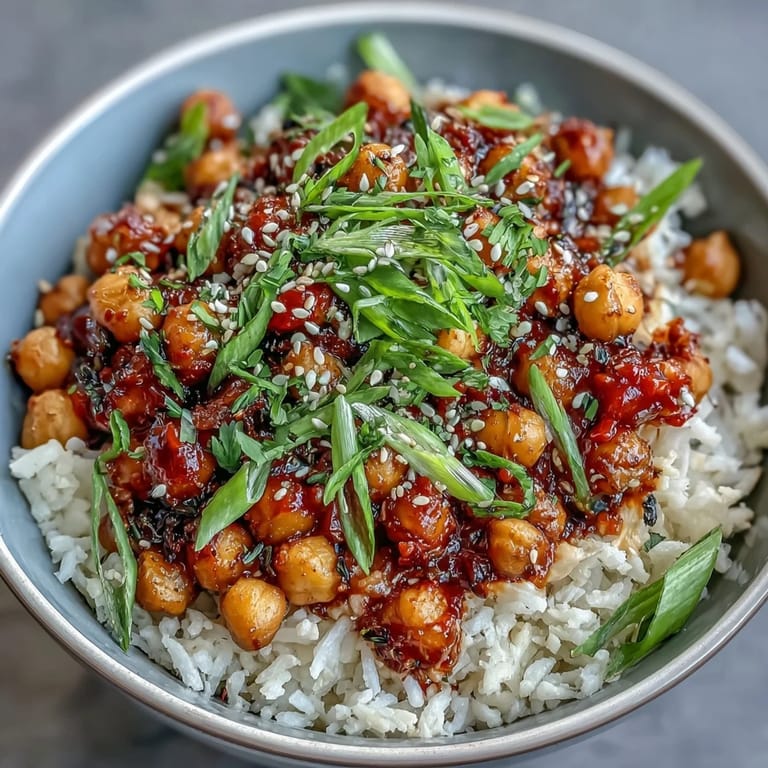 Golden roasted chickpeas coated in bold chili-garlic sauce, paired with fluffy jasmine rice and fresh cilantro for vibrant flavor.